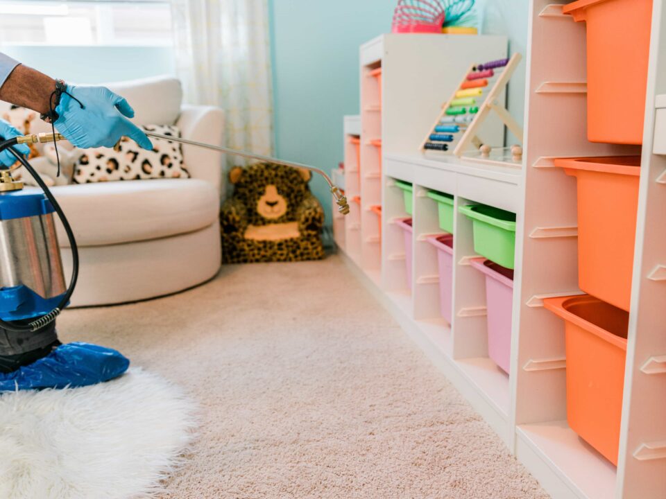 Pest control technician applies treatment in a clean nursery.